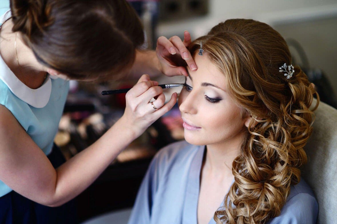 A person applying makeup to bridal